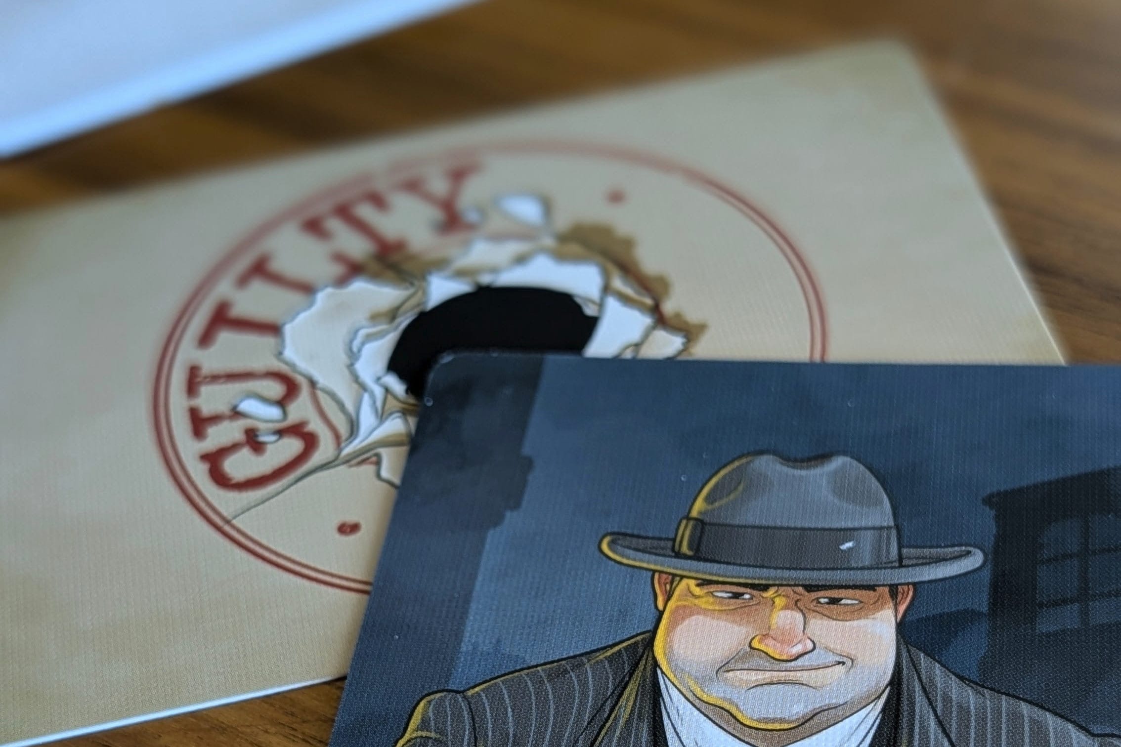 Card featuring a character in a suit and hat with text on a wooden surface